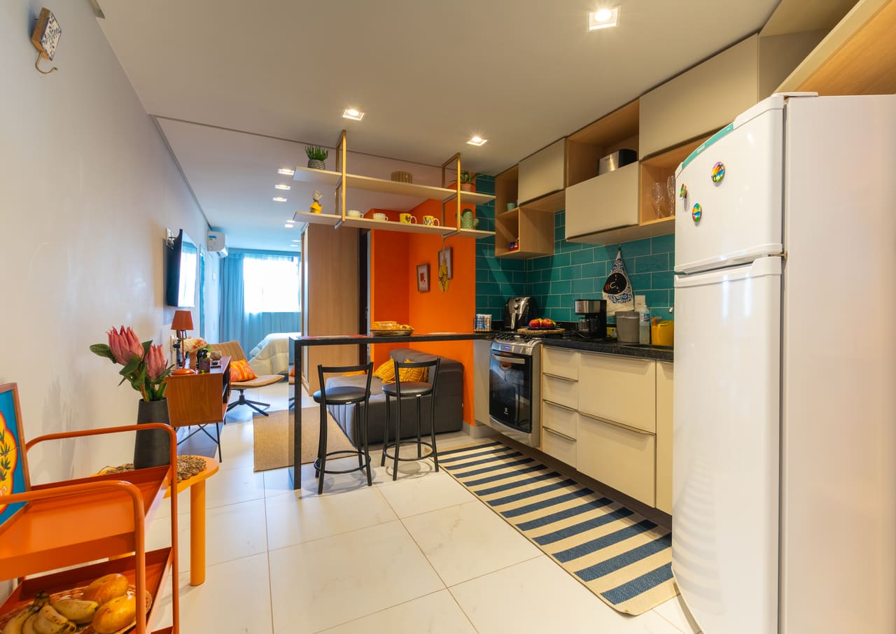Sala e cozinha integradas, com bancada e boa luz natural