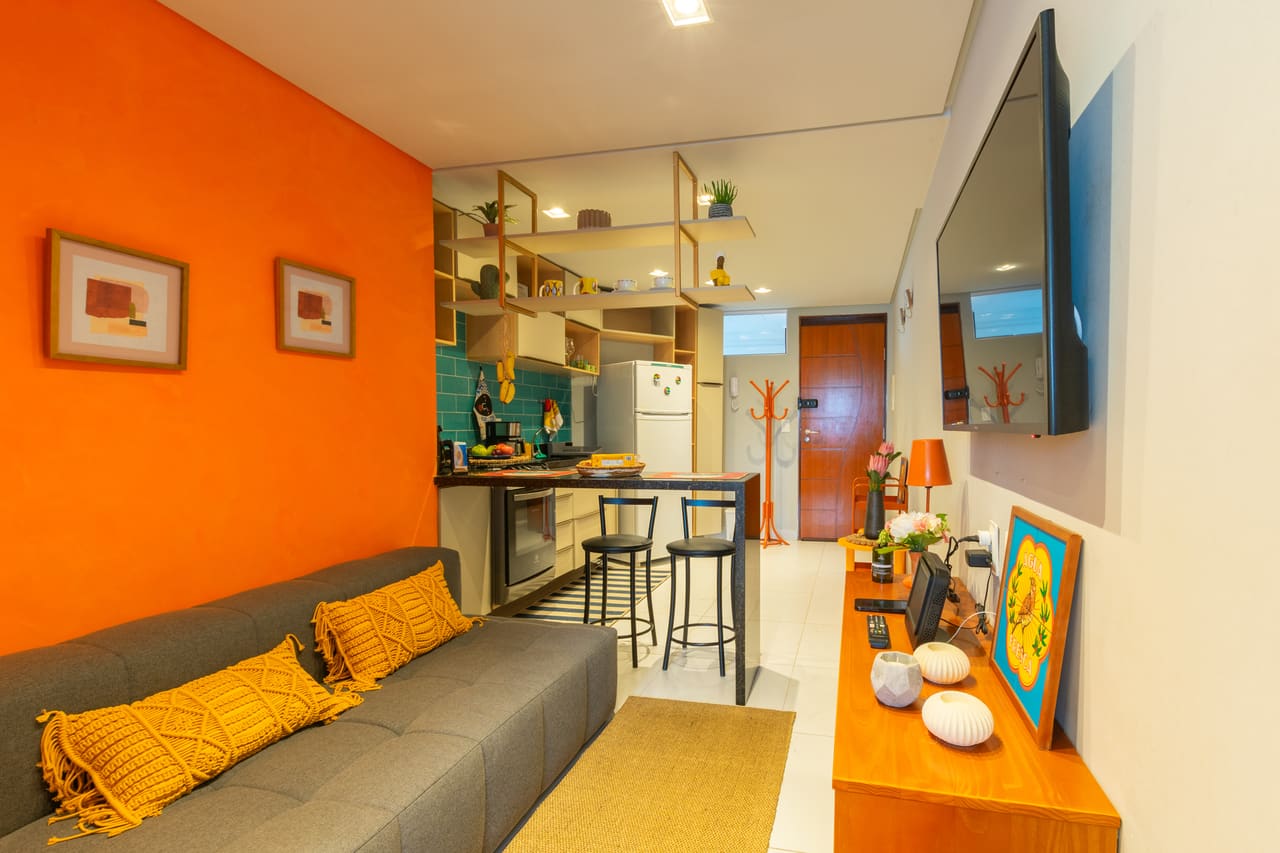 Sala de estar com sofá e parede laranja